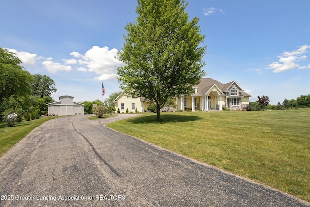 5056 W Bunker Rd, Mason, MI 48854 - view of front of home with a front lawn, an outdoor structure, and stone siding