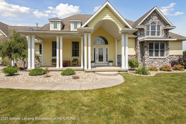 5056 W Bunker Rd, Mason, MI 48854 - view of front of property featuring a porch, roof with shingles, stone siding, and a front yard
