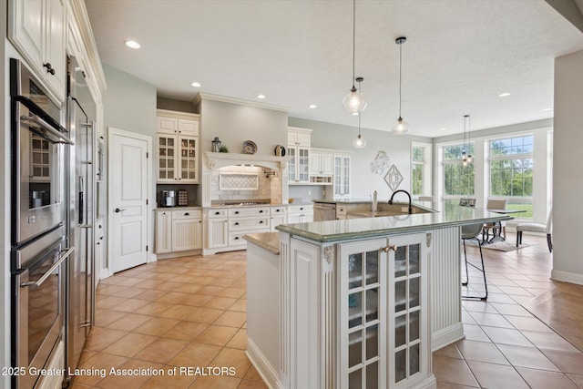 5056 W Bunker Rd, Mason, MI 48854 - kitchen with appliances with stainless steel finishes, light tile patterned flooring, a large island with sink, a breakfast bar area, and glass insert cabinets