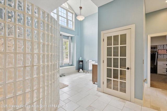 5056 W Bunker Rd, Mason, MI 48854 - bathroom featuring a walk in closet, tile patterned floors, and a high ceiling