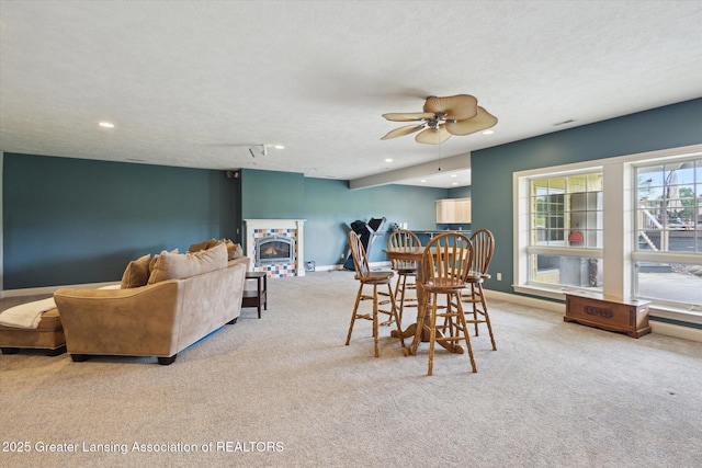 5056 W Bunker Rd, Mason, MI 48854 - dining space featuring light colored carpet, a ceiling fan, recessed lighting, and a warm lit fireplace