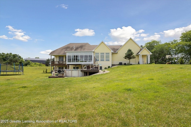 5056 W Bunker Rd, Mason, MI 48854 - rear view of house with a trampoline, a yard, a sunroom, and a deck