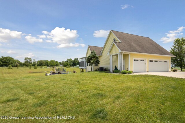 5056 W Bunker Rd, Mason, MI 48854 - view of side of home with concrete driveway, a lawn, an attached garage, and a shingled roof