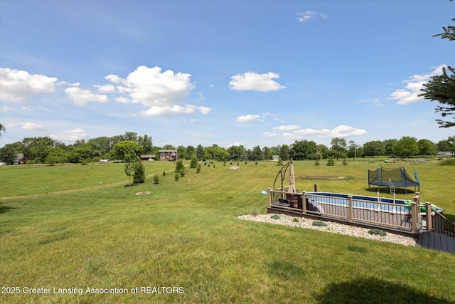 5056 W Bunker Rd, Mason, MI 48854 - view of green lawn featuring a trampoline and a rural view