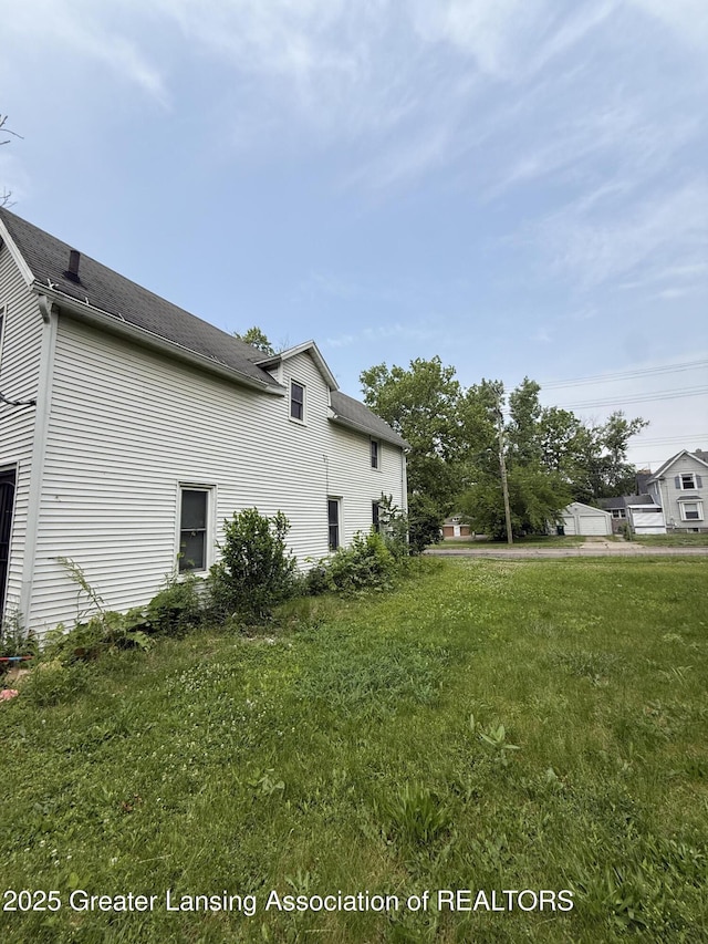 1018 E Kalamazoo St, Lansing, MI 48912 - view of side of property with a shingled roof and a lawn