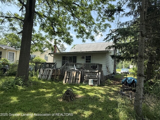 4317 S Cedar St, Lansing, MI 48910 - rear view of house featuring a wooden deck and a lawn