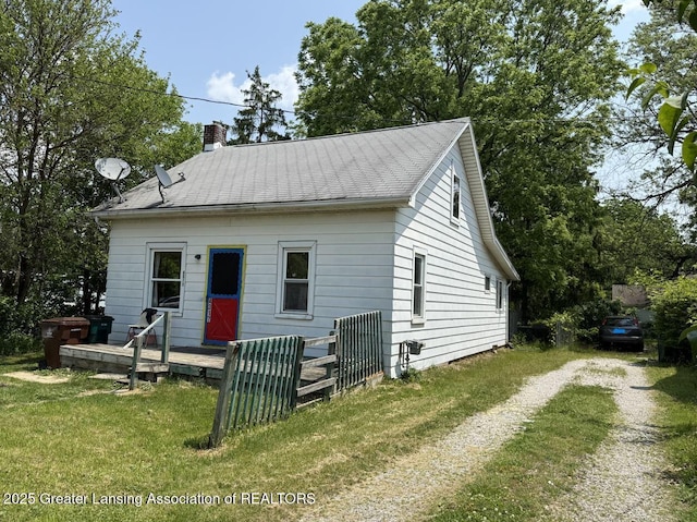 4317 S Cedar St, Lansing, MI 48910 - view of front of property with a wooden deck, a chimney, and a front yard