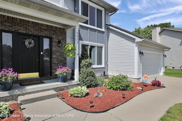 5925 Cabrena Dr, Lansing, MI 48917 - entrance to property featuring brick siding, driveway, and a garage