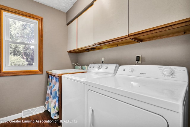 5925 Cabrena Dr, Lansing, MI 48917 - washroom featuring cabinet space, washing machine and dryer, and dark wood-style flooring