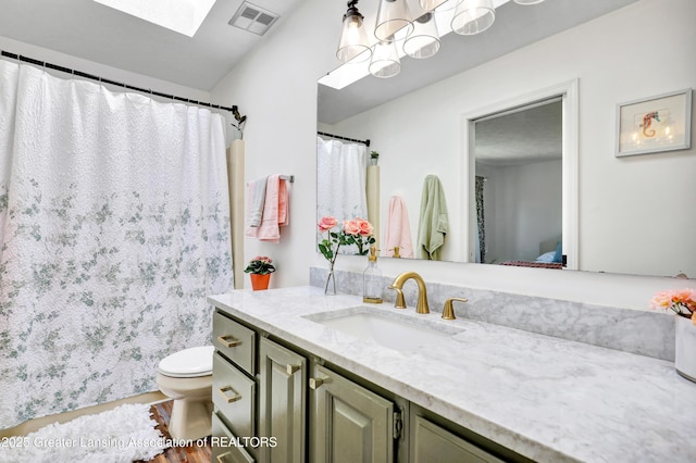 5925 Cabrena Dr, Lansing, MI 48917 - bathroom with a skylight, vanity, and wood finished floors