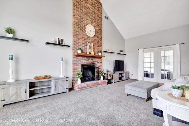 5925 Cabrena Dr, Lansing, MI 48917 - carpeted living area with high vaulted ceiling, a brick fireplace, and french doors