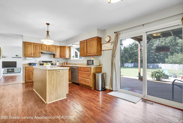 5925 Cabrena Dr, Lansing, MI 48917 - kitchen with appliances with stainless steel finishes, a kitchen island, light countertops, and dark wood-style flooring