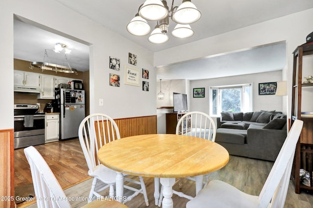 314 Scarlet Oak Ln, Perry, MI 48872 - dining room with wood finished floors, a chandelier, a wainscoted wall, and wood walls
