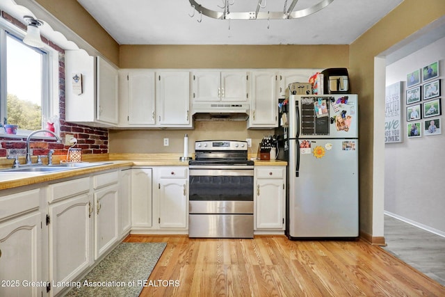 314 Scarlet Oak Ln, Perry, MI 48872 - kitchen featuring freestanding refrigerator, stainless steel range with electric cooktop, under cabinet range hood, white cabinetry, and light wood finished floors