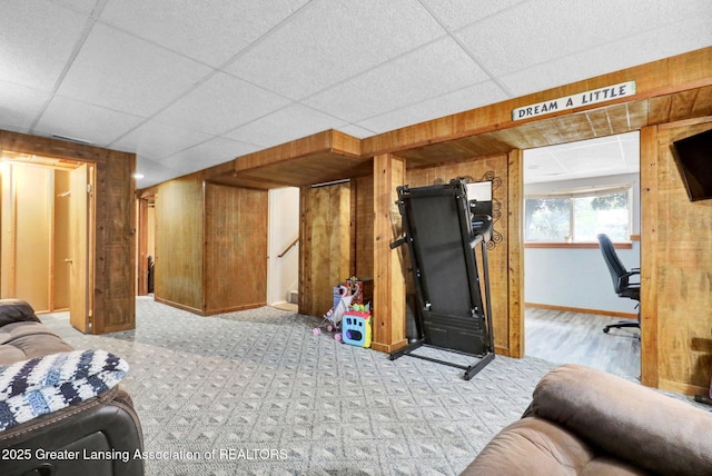 314 Scarlet Oak Ln, Perry, MI 48872 - carpeted living room featuring wooden walls, stairway, a desk, and a drop ceiling