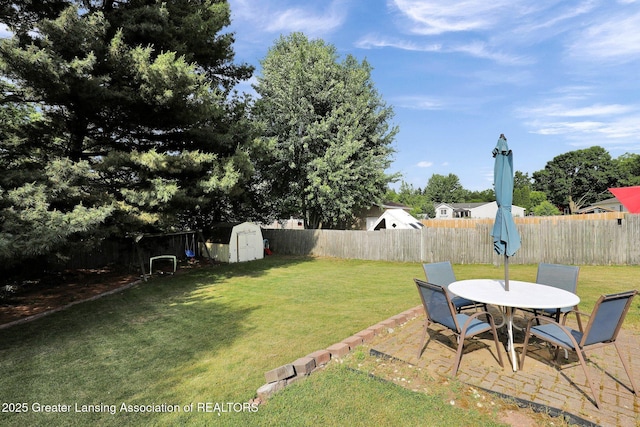 314 Scarlet Oak Ln, Perry, MI 48872 - fenced backyard featuring a storage unit, a patio area, and outdoor dining space