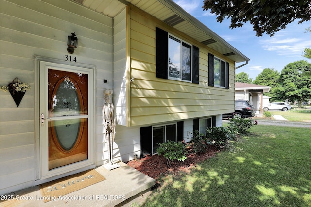 314 Scarlet Oak Ln, Perry, MI 48872 - view of exterior entry with a lawn