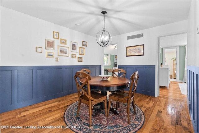 520 Wood St, Eaton Rapids, MI 48827 - dining room featuring wainscoting, wood finished floors, a chandelier, and a decorative wall