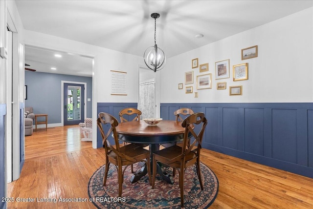 520 Wood St, Eaton Rapids, MI 48827 - dining space featuring light wood-style floors, wainscoting, and a chandelier