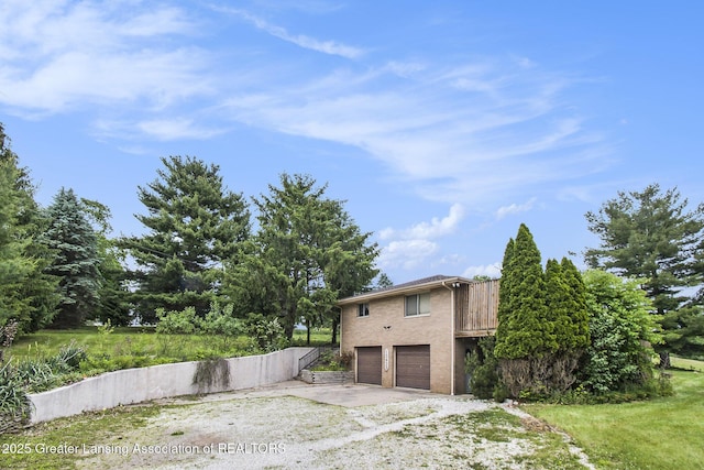 13433 S Grange Rd, Eagle, MI 48822 - view of property exterior featuring a garage and brick siding