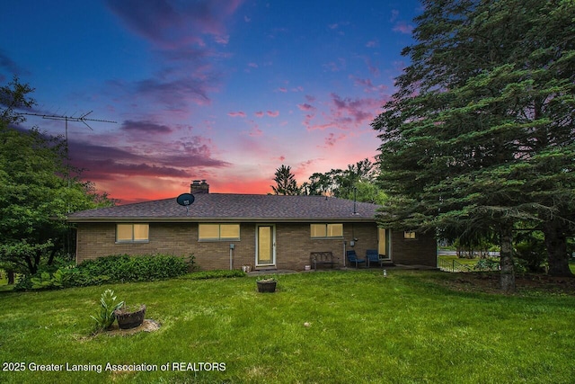 13433 S Grange Rd, Eagle, MI 48822 - view of front facade featuring a lawn, a chimney, and brick siding