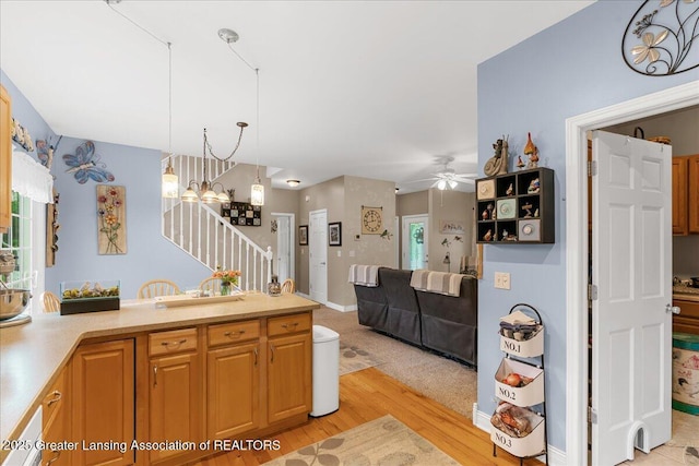 8805 E Cole Rd, Durand, MI 48429 - kitchen with light wood finished floors, light countertops, ceiling fan, a chandelier, and decorative light fixtures