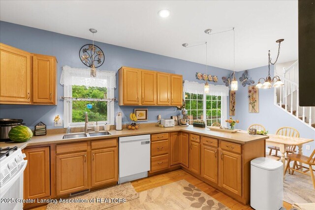 8805 E Cole Rd, Durand, MI 48429 - kitchen with white appliances, a chandelier, light countertops, light wood-style flooring, and pendant lighting