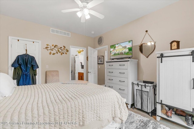 8805 E Cole Rd, Durand, MI 48429 - bedroom with a barn door and light wood-type flooring