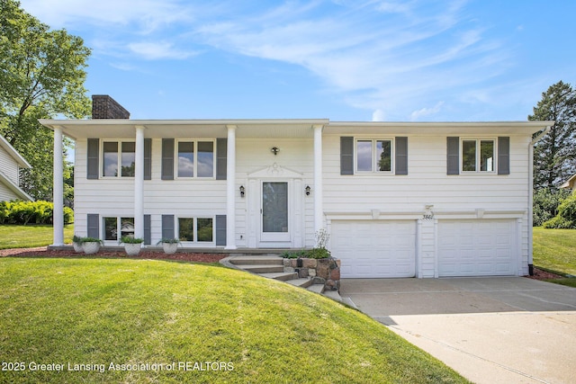 3861 New Salem Ave, Okemos, MI 48864 - bi-level home with a chimney, driveway, an attached garage, and a front lawn