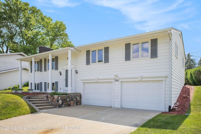 3861 New Salem Ave, Okemos, MI 48864 - raised ranch with concrete driveway, an attached garage, and a chimney