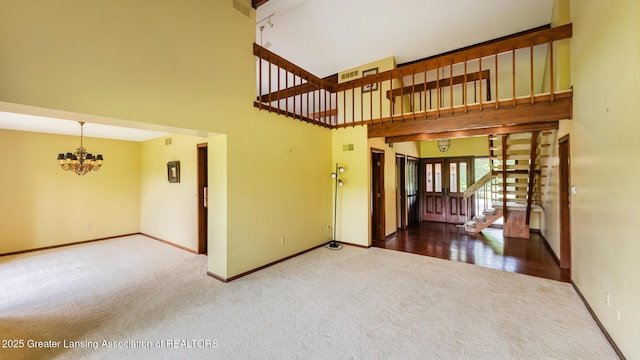 280 Winterberry Ln, Okemos, MI 48864 - entryway featuring carpet floors, a chandelier, a towering ceiling, and stairs
