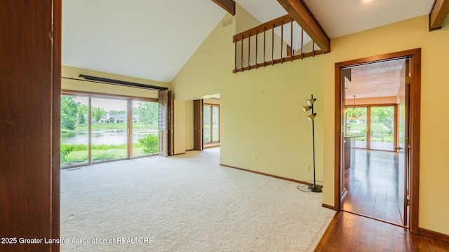 280 Winterberry Ln, Okemos, MI 48864 - empty room with high vaulted ceiling, beamed ceiling, a water view, wood finished floors, and carpet