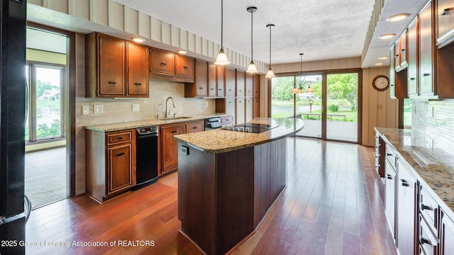 280 Winterberry Ln, Okemos, MI 48864 - kitchen with wood finished floors, brown cabinetry, tasteful backsplash, a kitchen island, and light stone countertops