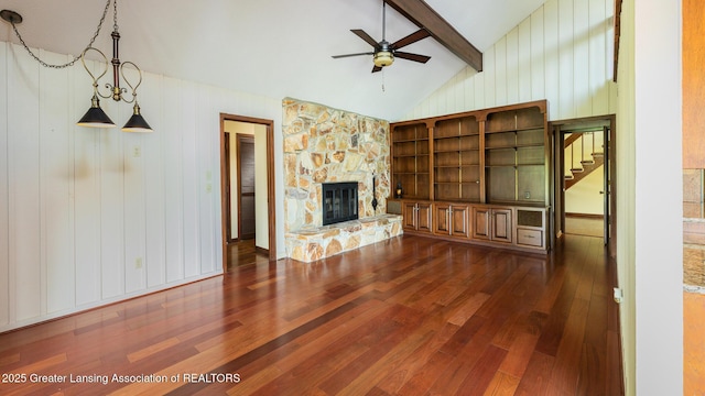 280 Winterberry Ln, Okemos, MI 48864 - unfurnished living room featuring dark wood-style flooring, ceiling fan, stairs, a fireplace, and wood walls