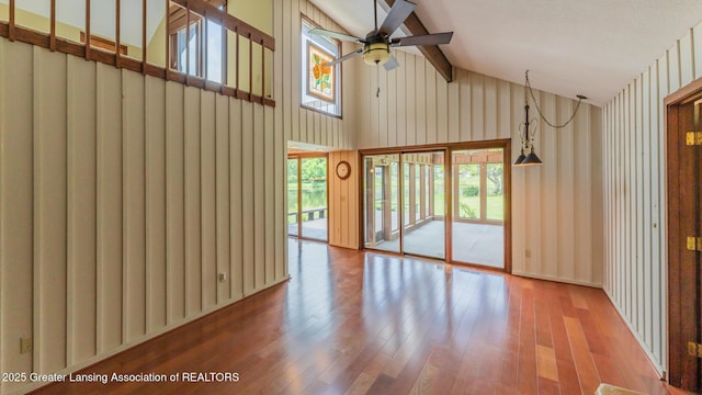 280 Winterberry Ln, Okemos, MI 48864 - unfurnished living room featuring ceiling fan, healthy amount of natural light, high vaulted ceiling, wood finished floors, and beam ceiling