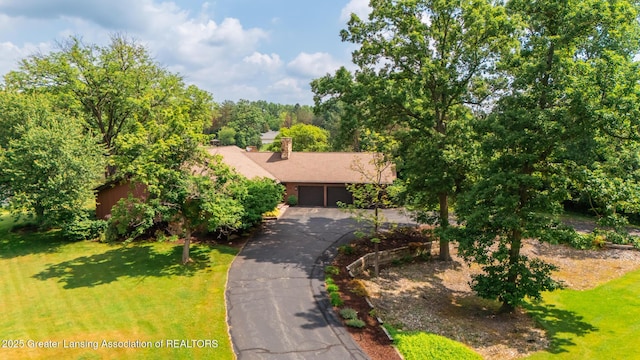 280 Winterberry Ln, Okemos, MI 48864 - obstructed view of property featuring a front lawn, asphalt driveway, a chimney, and an attached garage