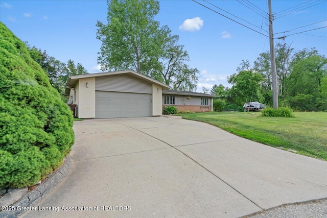 10138 Baron Blvd, Dimondale, MI 48821 - view of front facade with an attached garage, driveway, a front lawn, and stucco siding