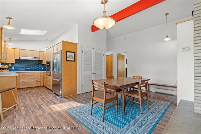 10138 Baron Blvd, Dimondale, MI 48821 - dining area featuring a skylight, a baseboard heating unit, dark wood finished floors, and high vaulted ceiling