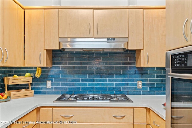 10138 Baron Blvd, Dimondale, MI 48821 - kitchen with light brown cabinets, range hood, appliances with stainless steel finishes, light countertops, and decorative backsplash