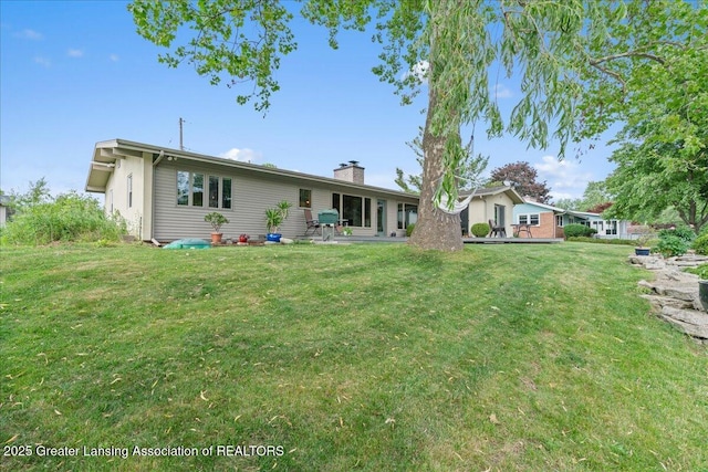 10138 Baron Blvd, Dimondale, MI 48821 - rear view of property featuring a chimney and a lawn