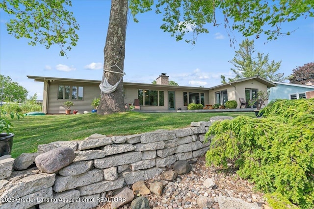 10138 Baron Blvd, Dimondale, MI 48821 - rear view of house with a chimney and a yard