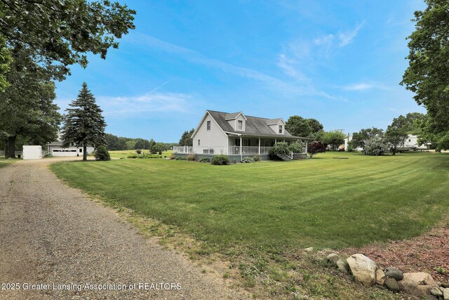 14235 Saxton Rd, Springport, MI 49284 - view of side of home featuring a porch, a yard, driveway, and a garage