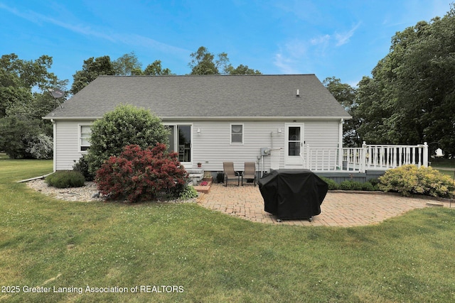 14235 Saxton Rd, Springport, MI 49284 - back of house with a patio area, a wooden deck, a lawn, and a shingled roof