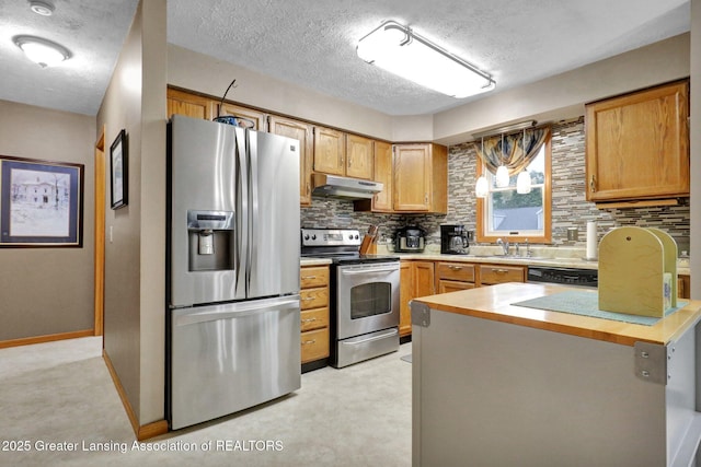 14235 Saxton Rd, Springport, MI 49284 - kitchen with appliances with stainless steel finishes, under cabinet range hood, tasteful backsplash, a textured ceiling, and a peninsula