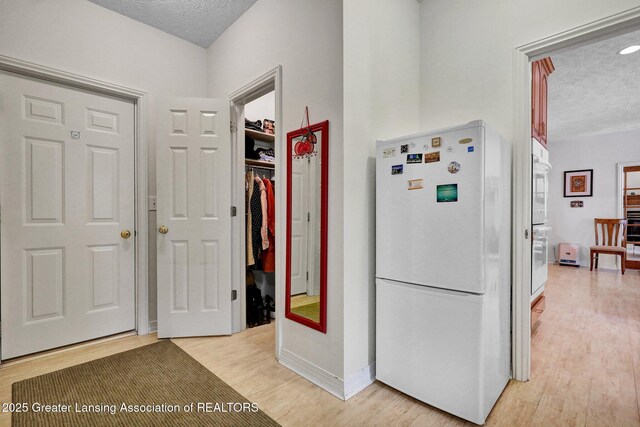 1823 Cricket Ln, East Lansing, MI 48823 - hall featuring a textured ceiling and light wood-style flooring
