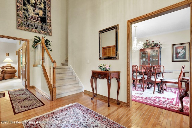 1823 Cricket Ln, East Lansing, MI 48823 - foyer featuring wood finished floors, stairs, and a chandelier