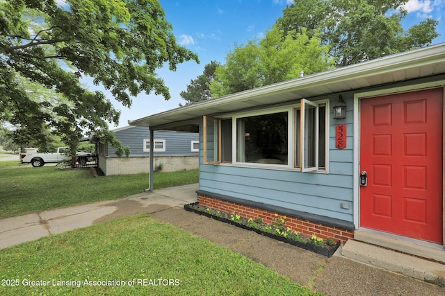 528 Thomas L Pkwy, Lansing, MI 48917 - doorway to property with a lawn