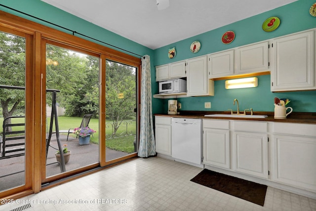 528 Thomas L Pkwy, Lansing, MI 48917 - kitchen with white appliances, dark countertops, white cabinetry, and light flooring