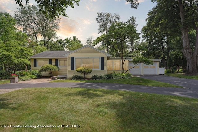 2391 Shawnee Trl, Okemos, MI 48864 - ranch-style house with a lawn and a detached garage