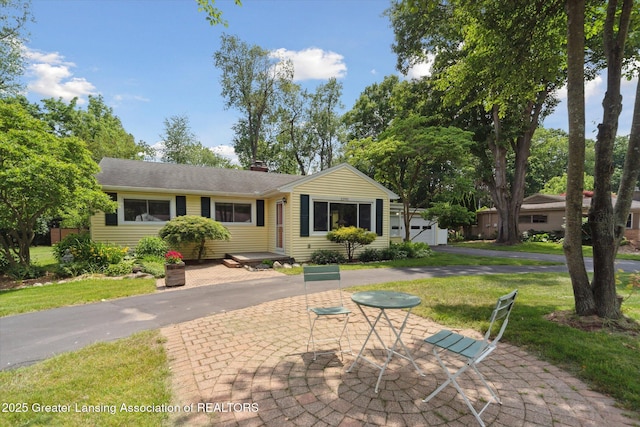 2391 Shawnee Trl, Okemos, MI 48864 - single story home with a front lawn, a chimney, and a garage